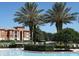 Community pool and lush landscaping with seating overlooking the lake and nearby buildings at 6117 Metrowest Blvd # 106, Orlando, FL 32835