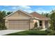 Inviting single-story home featuring a two-car garage and manicured lawn at 715 Chestnut Ln, Auburndale, FL 33823