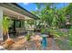 Charming backyard with a covered patio, bench seating, and various potted plants at 808 Denton Rd, Winter Park, FL 32792