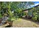 Expansive backyard with a covered patio, a stone fire pit, and plenty of greenery at 808 Denton Rd, Winter Park, FL 32792