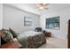 Cozy bedroom featuring a ceiling fan, large windows, a floral comforter and comfortable seating at 808 Denton Rd, Winter Park, FL 32792