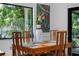 Bright dining room with a large window overlooking lush greenery and a wooden table with seating for six at 808 Denton Rd, Winter Park, FL 32792