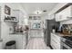 Bright kitchen featuring white cabinets, stainless steel appliances, and granite countertops at 808 Denton Rd, Winter Park, FL 32792