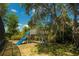 Backyard with a wooden playset and slide, nestled under mature trees and green foliage at 8735 Rancho Ct, Orlando, FL 32836