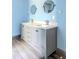Bathroom vanity with double sinks, gray cabinets, marble countertop and wood-look tile floors at 8735 Rancho Ct, Orlando, FL 32836