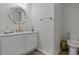 Elegant powder room featuring a modern vanity, round mirror, and neutral color palette at 15160 Avenue Of The Arbors, Winter Garden, FL 34787