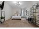 Bright, carpeted bedroom with a TV, a stylish chandelier, and a functional vanity at 15160 Avenue Of The Arbors, Winter Garden, FL 34787