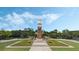 Beautifully landscaped clock tower set against a blue sky, adding charm and character to the community at 15160 Avenue Of The Arbors, Winter Garden, FL 34787