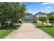 Long brick driveway leading to the attached garage with a basketball hoop at 15160 Avenue Of The Arbors, Winter Garden, FL 34787