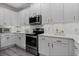 Well-lit kitchen showcasing white cabinets, subway tile backsplash, stainless steel appliances and quartz countertops at 15160 Avenue Of The Arbors, Winter Garden, FL 34787
