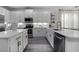 Bright kitchen featuring white cabinets, stainless steel appliances, quartz countertops, and modern fixtures at 15160 Avenue Of The Arbors, Winter Garden, FL 34787