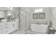Luxurious bathroom featuring a soaking tub, glass-enclosed shower, and elegant fixtures at 161 Purcell Dr, Alafaya, FL 32825