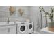 Well-equipped laundry room with white washer and dryer and stylish decor at 161 Purcell Dr, Alafaya, FL 32825