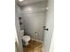 Clean half-bathroom with toilet, towel rack, and overhead shelf for added convenience at 2585 Grassy Point Dr # 313, Lake Mary, FL 32746