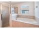 Bathroom featuring a separate shower, soaking tub, and a large window at 2907 Southern Pines Loop, Clermont, FL 34711