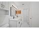 A well-lit bathroom features a double vanity, framed mirrors, and a door to the hallway at 3111 Pine Tree Dr, Edgewater, FL 32141