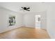 A bright bedroom offers hardwood floors, a ceiling fan, a window, and an ensuite bathroom at 3111 Pine Tree Dr, Edgewater, FL 32141