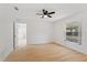 A sunny bedroom features hardwood floors, a ceiling fan, a window, and ensuite access at 3111 Pine Tree Dr, Edgewater, FL 32141