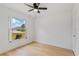 A bright bedroom features hardwood floors, a ceiling fan, and a large window at 3111 Pine Tree Dr, Edgewater, FL 32141