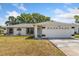 Charming single-story home featuring a two-car garage, well-maintained lawn, and modern architectural details at 3111 Pine Tree Dr, Edgewater, FL 32141