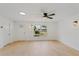 Open living area with light wood flooring, modern ceiling fan, and abundant natural light at 3111 Pine Tree Dr, Edgewater, FL 32141