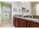 Bathroom with dual sinks, granite countertops, and cherry-wood cabinets at 3321 San Jacinto Cir # 116, Sanford, FL 32771