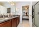 Bathroom with granite countertop, wooden cabinets, tiled floor, shower, and view into bedroom at 3321 San Jacinto Cir # 116, Sanford, FL 32771