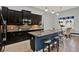Well-appointed kitchen with black cabinets, granite counters, island with seating, and stainless appliances at 3716 Paradiso Cir, Kissimmee, FL 34746
