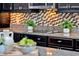 Close-up of kitchen with granite countertops, mosaic backsplash, dark wood cabinets, and electric cooktop at 3716 Paradiso Cir, Kissimmee, FL 34746
