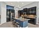 Modern kitchen with dark cabinets, stainless steel appliances, kitchen island, and bar stool seating at 3716 Paradiso Cir, Kissimmee, FL 34746