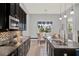 Stylish kitchen with black cabinetry, granite countertops, stainless appliances, and adjacent dining area at 3716 Paradiso Cir, Kissimmee, FL 34746