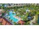 Aerial view of a large community pool with a lazy river, palm trees, and lounge chairs at 4201 Oakview Dr, Davenport, FL 33837