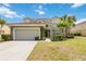 Charming two-story home featuring a well-manicured lawn, two-car garage, and classic tile roof at 4201 Oakview Dr, Davenport, FL 33837