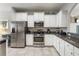 Kitchen with stainless steel appliances, white cabinets, and dark granite counter tops at 4201 Oakview Dr, Davenport, FL 33837