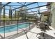 Screened-in pool area featuring a dining set, spa and lounge chair at 4201 Oakview Dr, Davenport, FL 33837
