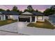 Charming single-story home with a gray brick driveway and a dark brown two-car garage at 59 W 10Th St, Apopka, FL 32703