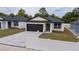 Charming single-story home with a well-manicured lawn, dark trim, and a paved driveway at 59 W 10Th St, Apopka, FL 32703