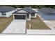 Eye-level view of a single-story home with a dark garage door and a paved driveway at 59 W 10Th St, Apopka, FL 32703