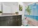 Bright bathroom featuring dark vanity with light countertop, tropical themed shower curtain, artwork and toilet at 8951 Amelia Downs Trl, Kissimmee, FL 34747