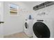 Bright laundry room featuring front loading washer/dryer and laundry themed wall art at 8951 Amelia Downs Trl, Kissimmee, FL 34747