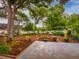 Expansive backyard with lush greenery, mature trees, a concrete patio, and manicured landscaping at 1145 Utah Blvd, Orlando, FL 32803