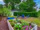 Backyard featuring raised garden beds with flowers, mature trees, and cozy seating area at 1145 Utah Blvd, Orlando, FL 32803