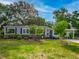 Inviting home with a well-manicured lawn, mature trees, a carport, gray siding, and dark shutters at 1145 Utah Blvd, Orlando, FL 32803
