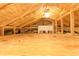 View of the spacious unfinished attic featuring insulation and structural elements at 1312 7Th St, St Cloud, FL 34769