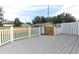 Back deck with white rails and a wooden fence surrounding a small shed at 1312 7Th St, St Cloud, FL 34769