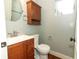 Bathroom features a wooden vanity with a sink, toilet, and overhead cabinet at 1312 7Th St, St Cloud, FL 34769