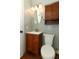 Bathroom features a wooden vanity with a sink, toilet, and overhead cabinet at 1312 7Th St, St Cloud, FL 34769
