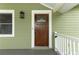 Close-up of a wood front door with decorative glass, surrounded by light green siding at 1312 7Th St, St Cloud, FL 34769