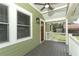 View of the front porch with light green walls, a wood door, and a ceiling fan at 1312 7Th St, St Cloud, FL 34769