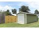 Exterior shot of the detached garage with green siding and fenced in area at 1312 7Th St, St Cloud, FL 34769